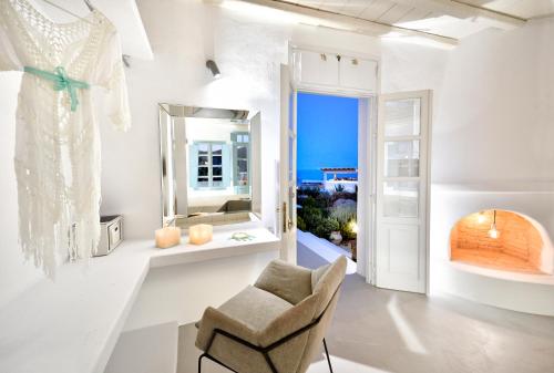 a white room with a chair and a mirror at Mykonos Pantheon in Kalo Livadi