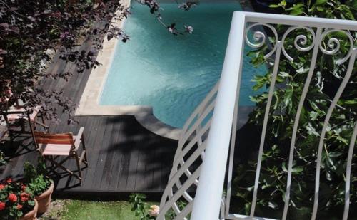 uma vista para uma piscina a partir de uma varanda em La Petite Maison em Villeneuve-lès-Avignon