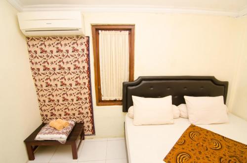 a small room with a bed and a table at Pendopo Andari Homestay in Yogyakarta