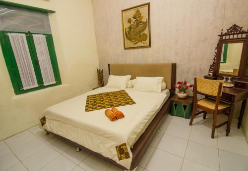 a bedroom with a bed and a table and a mirror at Pendopo Andari Homestay in Yogyakarta