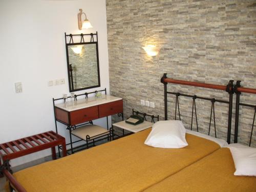 1 dormitorio con cama, lavabo y espejo en Iliovasilema, en Naxos Chora