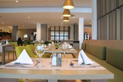 een eetkamer met tafels en stoelen met glazen en servetten bij JS Alcudi-Mar in Playa de Muro