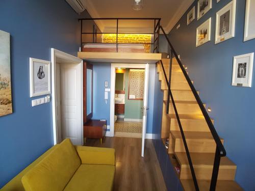 sala de estar con escalera y paredes azules en Apartamenty Czapskich, en Cracovia