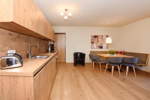 a kitchen with a sink and a table with chairs at Chalet Zamang in Schruns-Tschagguns