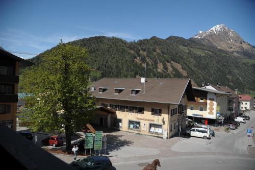 a building in a town with a mountain in the background at Gästehaus Obwexer in Matrei in Osttirol