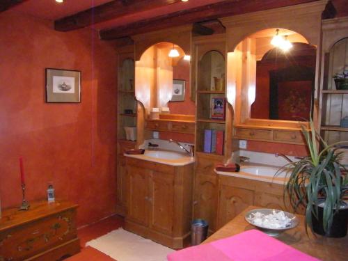 une salle de bain avec deux lavabos et deux miroirs dans l'établissement La Maison Jaune, à Vendenheim