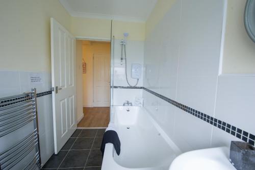 a bathroom with a bath tub and a shower at PREMIER - Park View Apartment in Paisley