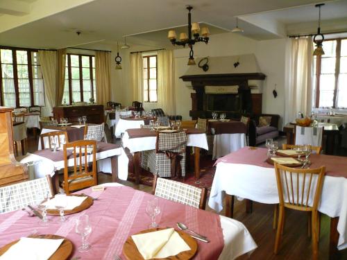 Châlet Hôtel d'Ailefroide في Ailefroide: مطعم بطاولات وكراسي ومدفأة