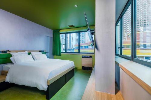 a bedroom with a large white bed and windows at YOOMA Urban Lodge Tour Eiffel in Paris