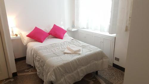 a bedroom with a bed with two pink pillows at Garden Suite in Genova
