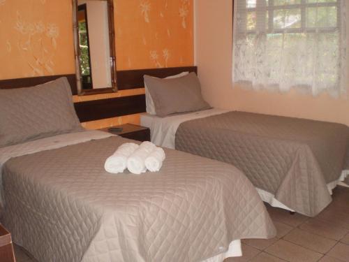 a hotel room with two beds with towels on them at Pousada Estrela do Mar in Ilha do Mel