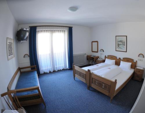 a hotel room with two beds and a window at Gästehaus Obwexer in Matrei in Osttirol