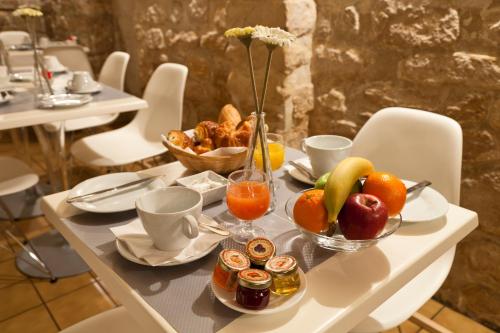 - une table avec un bol de fruits et un bol de pain dans l'établissement Hôtel Marais de Launay, à Paris