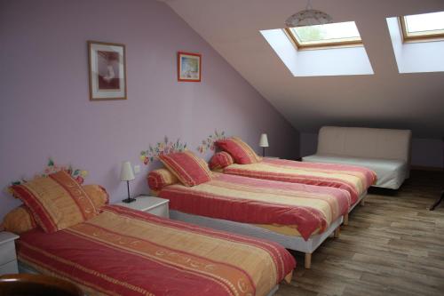 a attic room with three beds and a skylight at Au bois de mon coeur in Foameix
