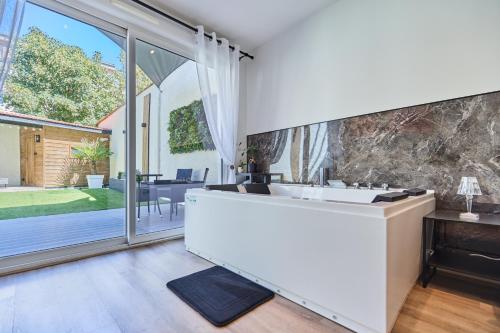 Secret garden SPA - Idéal couples et pros - 5min à pied de la gare - 10min à pied de l'Arena et du Quartier Boulingrin - Baignoire balnéo - Jardin privatif de 50m2 - Mini golf - Home cinéma