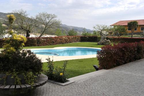 a swimming pool in the middle of a yard at Hotel Aguiar da Pena in Vila Pouca de Aguiar