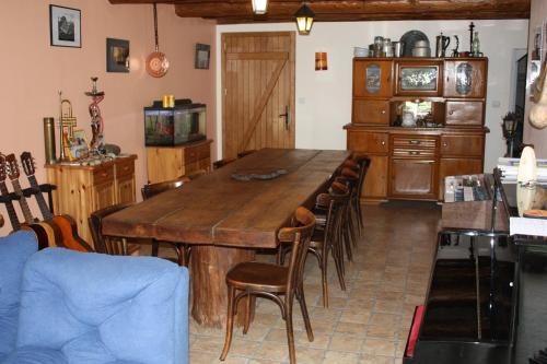 une salle à manger avec une grande table et des chaises en bois dans l'établissement Au bois de mon coeur, à Foameix