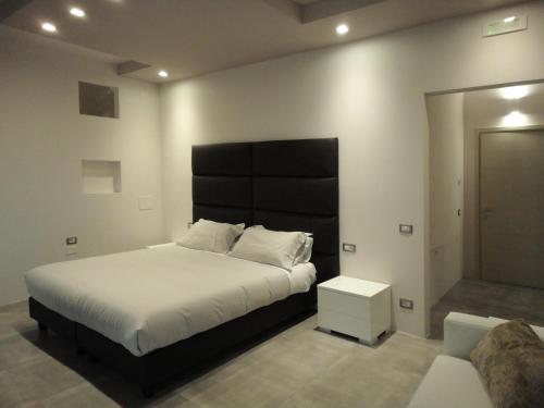 a bedroom with a large bed with a black headboard at The Flat 233 in Tavarnuzze