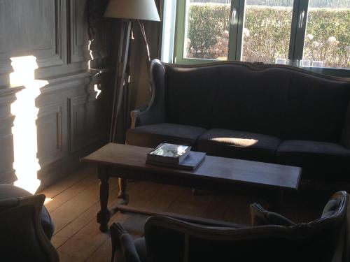 a living room with a couch and a coffee table at B&B Silentium in Tielt