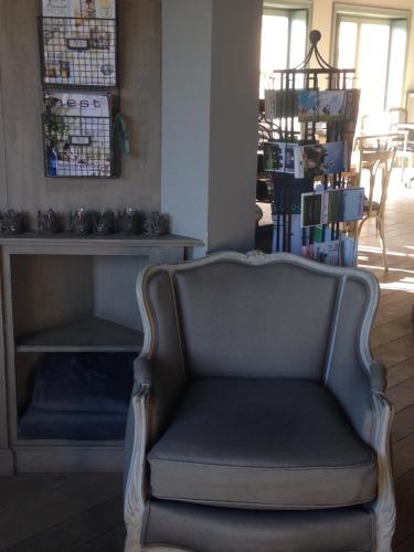 a chair sitting in a living room next to a fireplace at B&B Silentium in Tielt