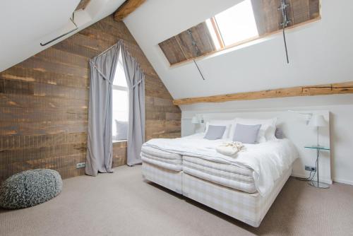 a bedroom with a large white bed and a window at Ne5t Hotel & Spa in Namur