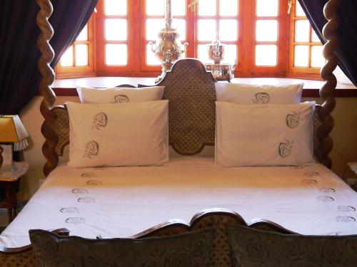 a bed with a wooden head board and pillows at Casa Taos in Marrakech