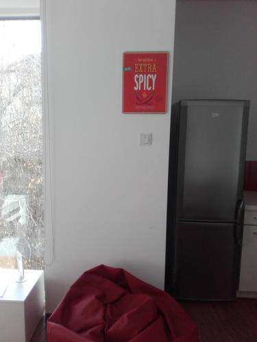 a kitchen with a refrigerator and a sign on the wall at Cube Apartamenty in Lublin