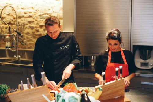 a man and a woman preparing food in a kitchen at Ne5t Hotel & Spa in Namur