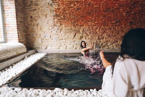 a woman taking a picture of a girl in a hot tub at Ne5t Hotel & Spa in Namur