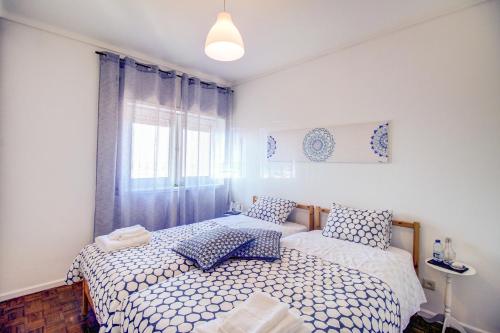 een slaapkamer met 2 bedden en een raam bij Ria do Sal in Aveiro