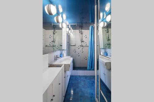 ボローニャにあるLe Grenierの青いバスルーム(シンク2台、シャワー付)