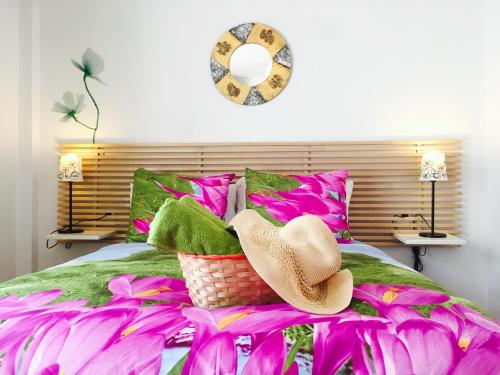 a bedroom with a bed with pink and green pillows at Axarquia Apartments in Nerja