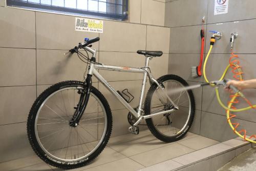 a bike in a bathroom with a person washing it at Hotel Villa Clara in Nago-Torbole
