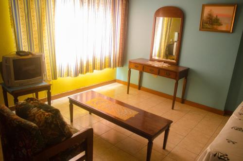 a living room with a table and a mirror at Turtle Beach Towers in Ocho Rios