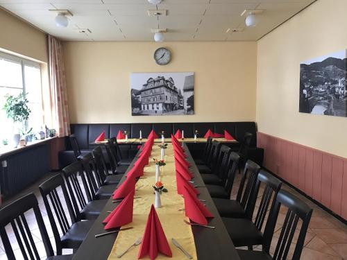 - une longue table avec des serviettes rouges dans une pièce dans l'établissement Hotel Restaurant Krone, à Nassau