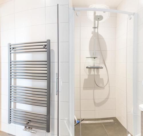 een douche met een glazen deur in de badkamer bij Zoutelande vakantiewoning in Zoutelande
