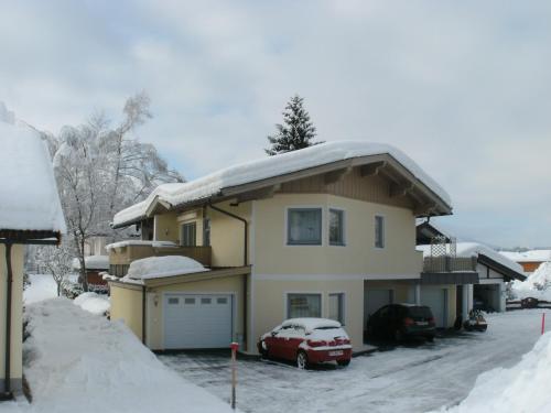 a house with snow on top of it at Haus am Achengrund in Kössen