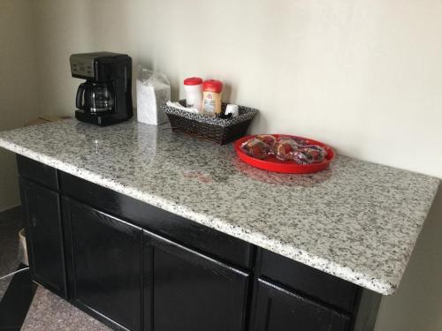 a granite counter top with a coffee maker on it at Moonlight Inn & Suites in Houston