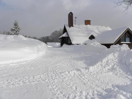 a pile of snow next to a house at Na Zvonici in Paseky nad Jizerou