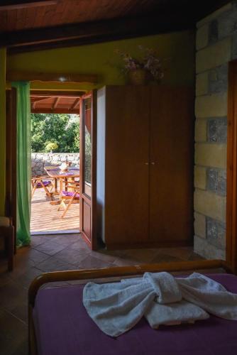 a room with a bed and a patio with a table at Villa Onar a stone house with amazing view in Stoupa