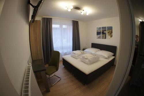 クックスハーフェンにあるResidenz Windjammerのベッドルーム1室(ベッド1台、椅子、鏡付)