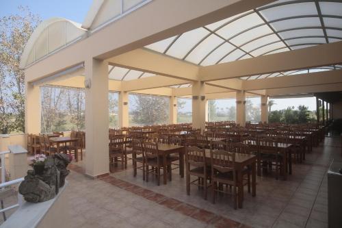 een grote eetkamer met tafels en stoelen bij Roseland's Hotel in Marmari
