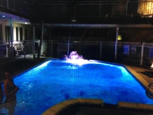 een zwembad met blauw water in de nacht bij Twilight Motel in Wildwood