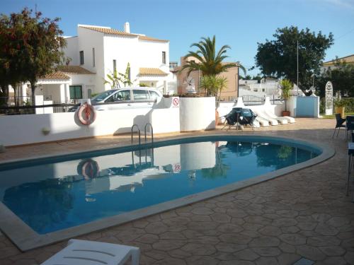 a swimming pool in front of a villa at Agua Marinha ROSA- Hotel in Albufeira