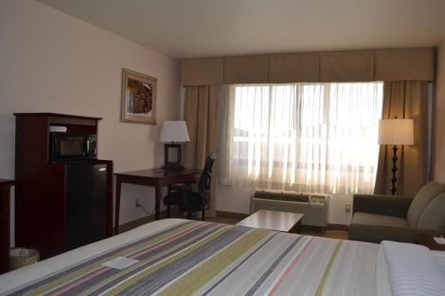 a hotel room with a bed and a living room at Country Inn & Suites by Radisson, Abingdon, VA in Abingdon