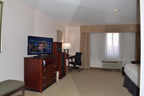 a hotel room with a bed and a television on a dresser at Country Inn & Suites by Radisson, Abingdon, VA in Abingdon