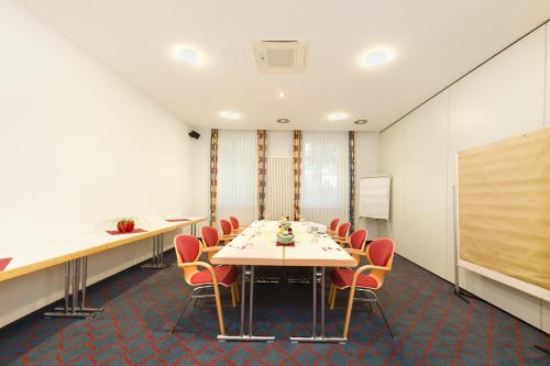 a conference room with a long table and chairs at Hotel Montana in Guxhagen