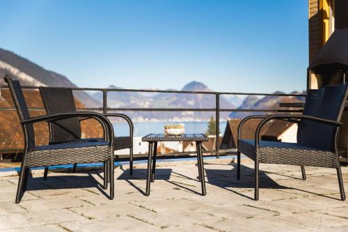 two chairs and a table on a balcony with a view at Pilatus Apartments in Alpnach