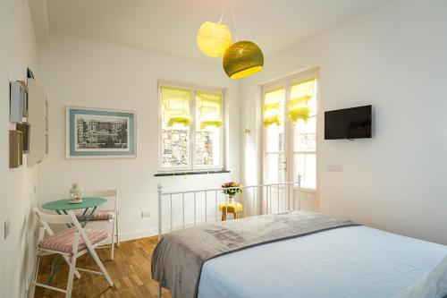 a bedroom with a bed and a table and windows at B&B VillaRocca da Ines e Perizia in Sestri Levante