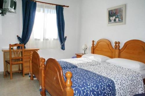 a bedroom with a bed and a desk and a window at La Vista Pension in Guía de Isora